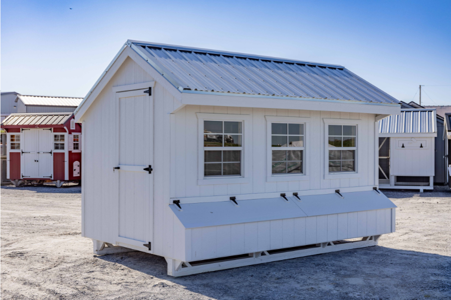 white quaker style chicken coop with meta roof